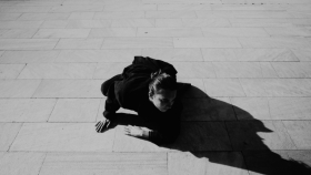Imatge en blanc i negre d'una noia ajaguda al terra