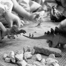 Imatge en blanc i negre de nens jugant amb dinosaures